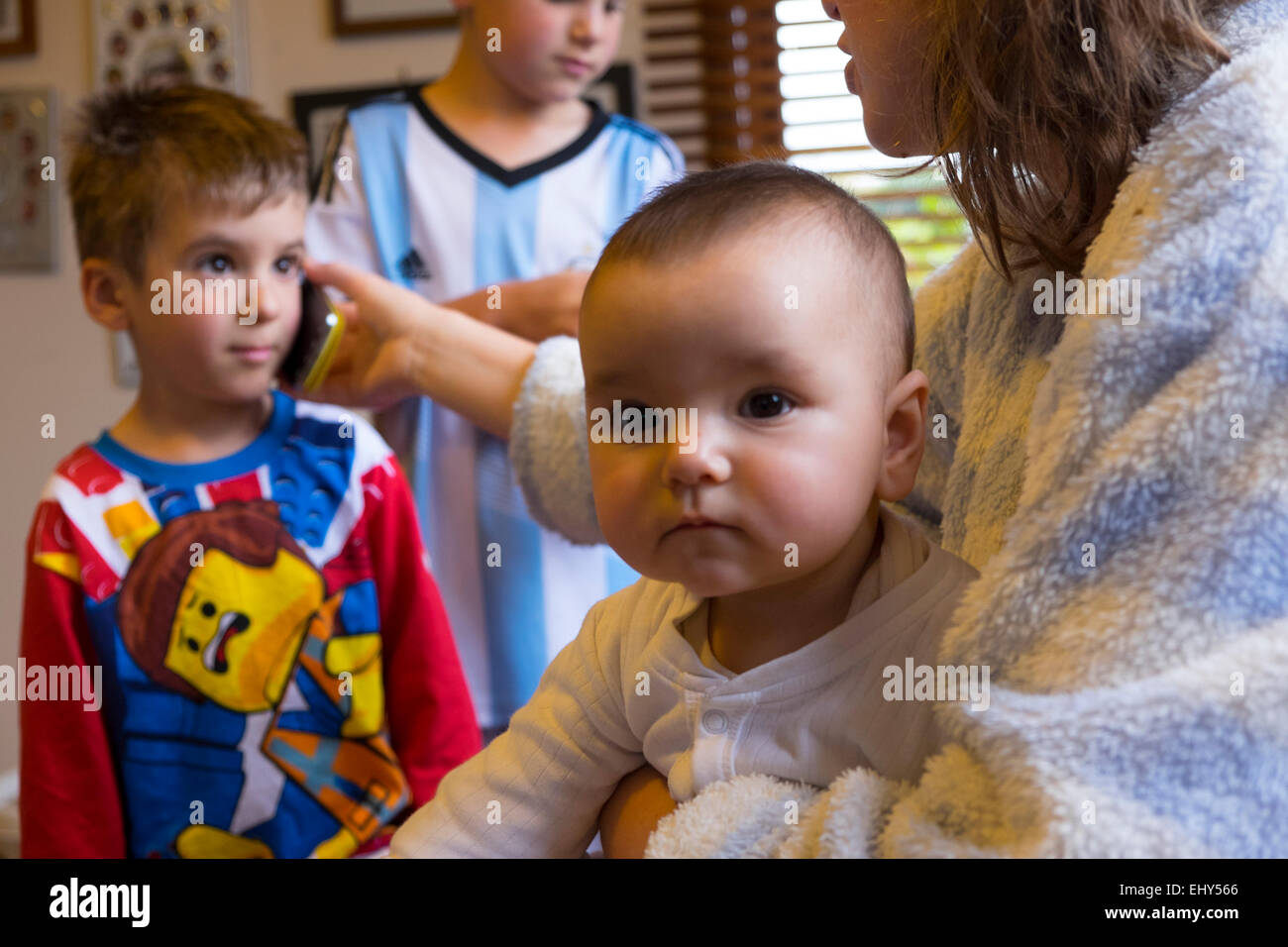 Child speaking on mobile phone with other family members Stock Photo