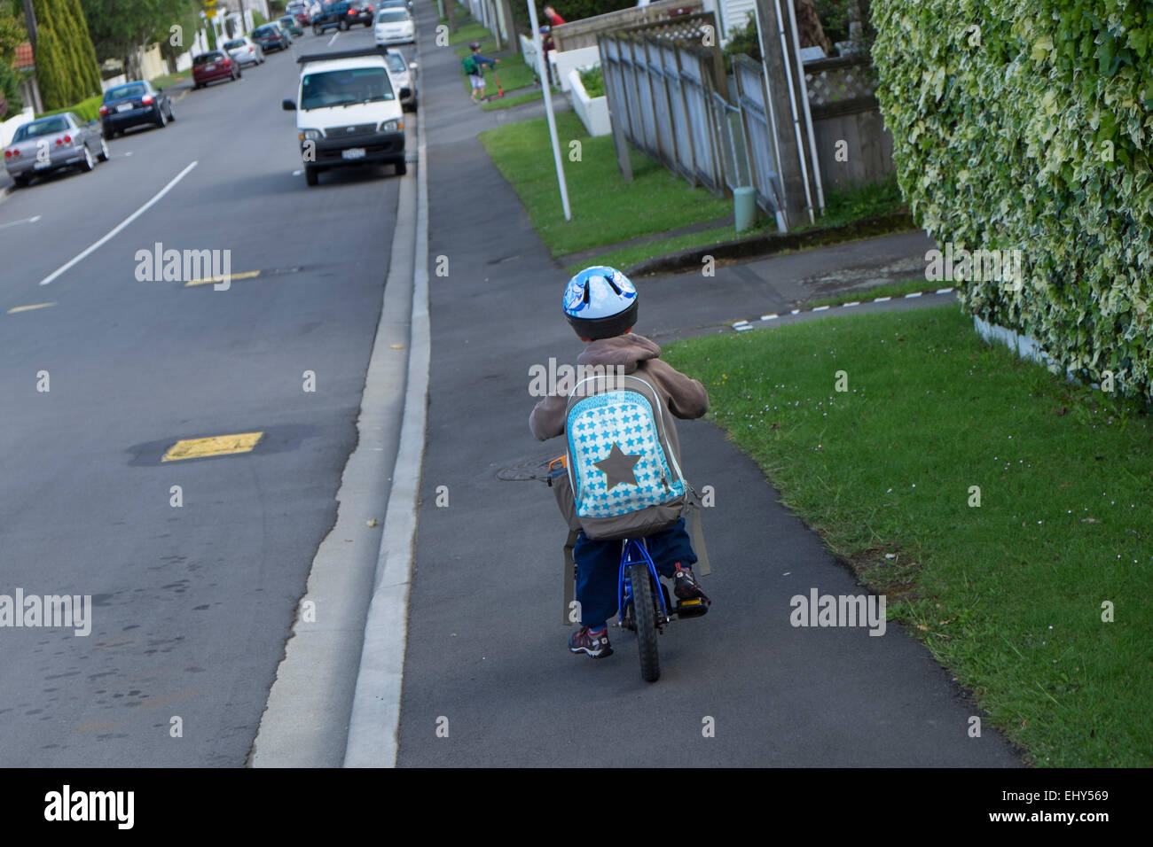 Four year old boy with backpack on bike, riding to School with helmet Stock Photo