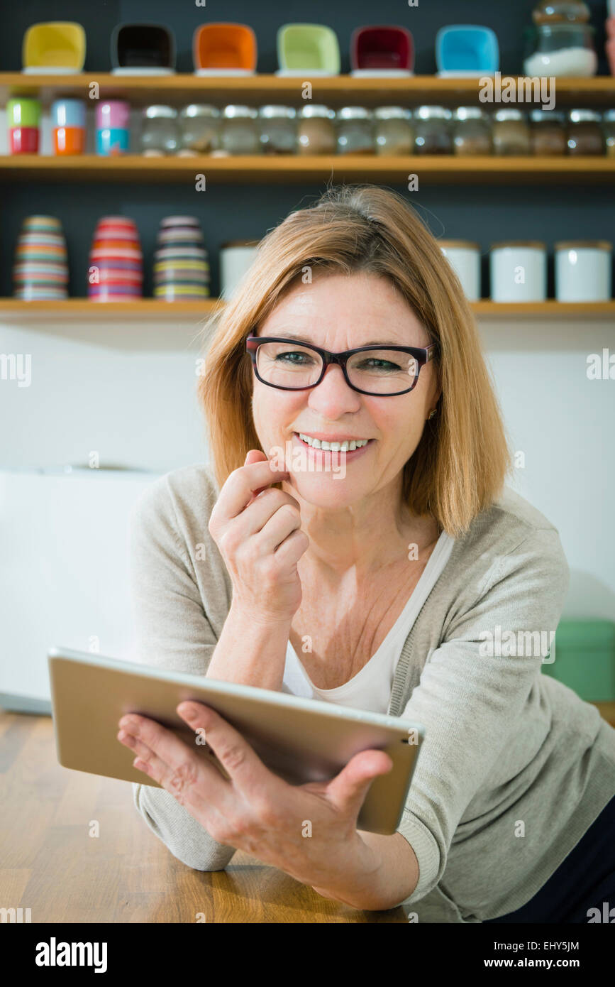 Senior woman in kitchen using tablet pc, portrait Stock Photo