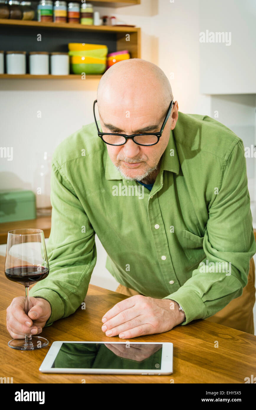 Senior man using digital tablet  in kitchen Stock Photo