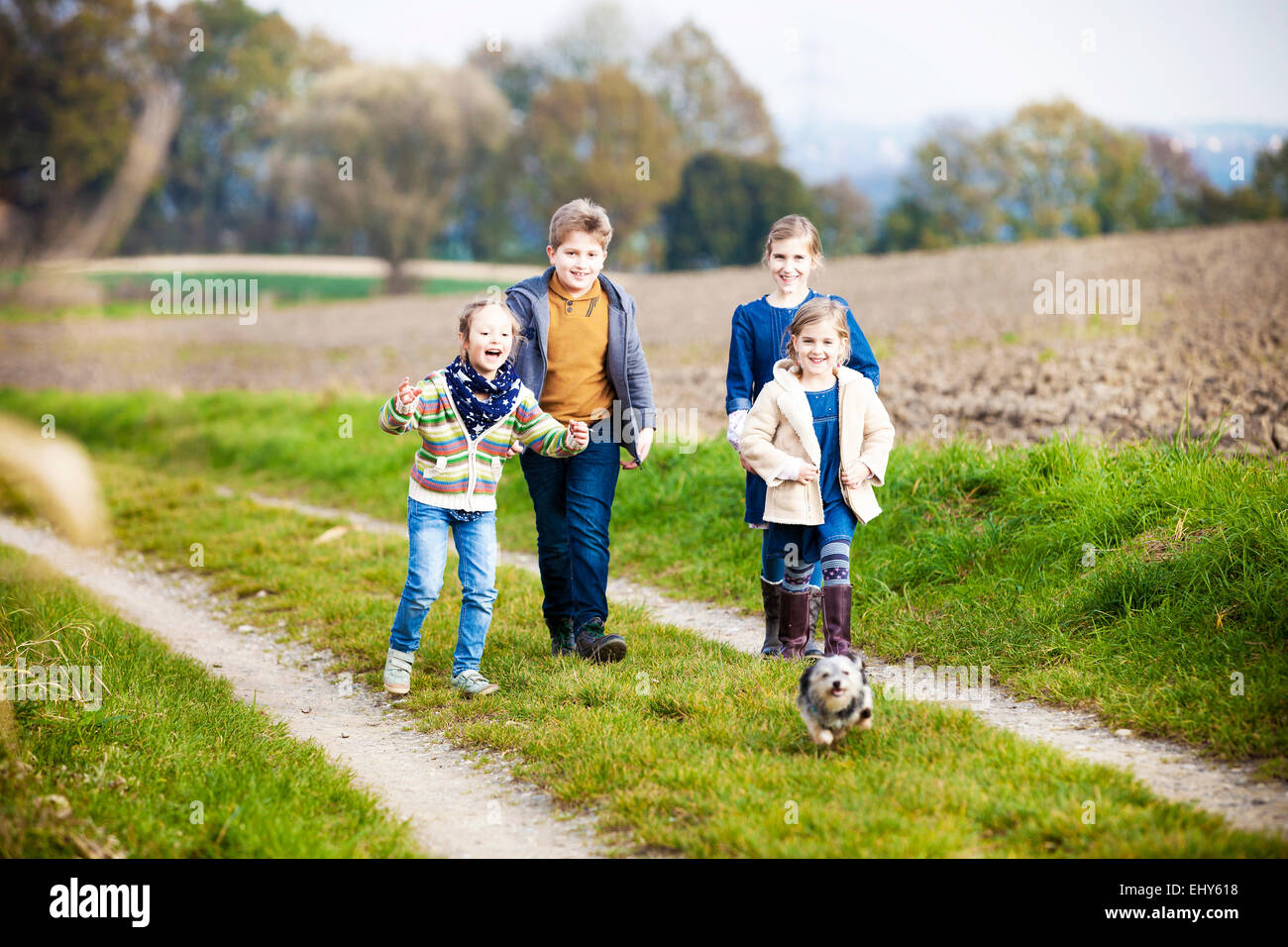 Children playing with dog outdoors Stock Photo