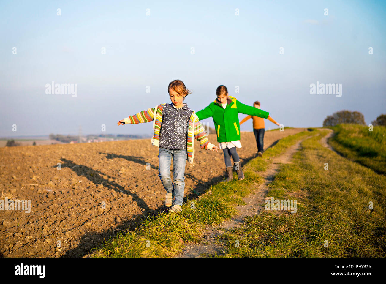 Three children playing outdoors Stock Photo