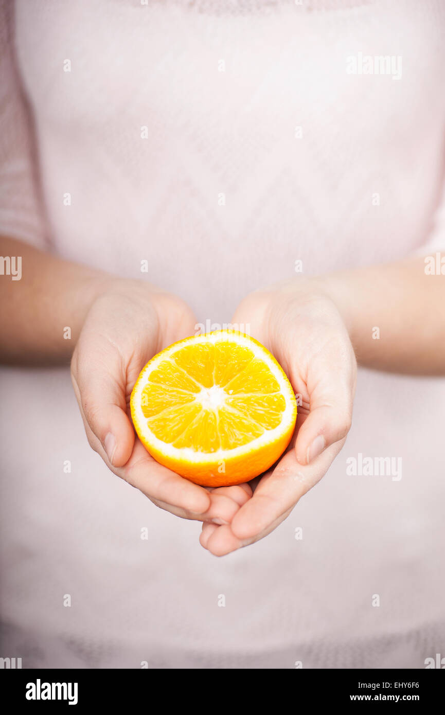 Human hand holding half orange hi-res stock photography and images - Alamy