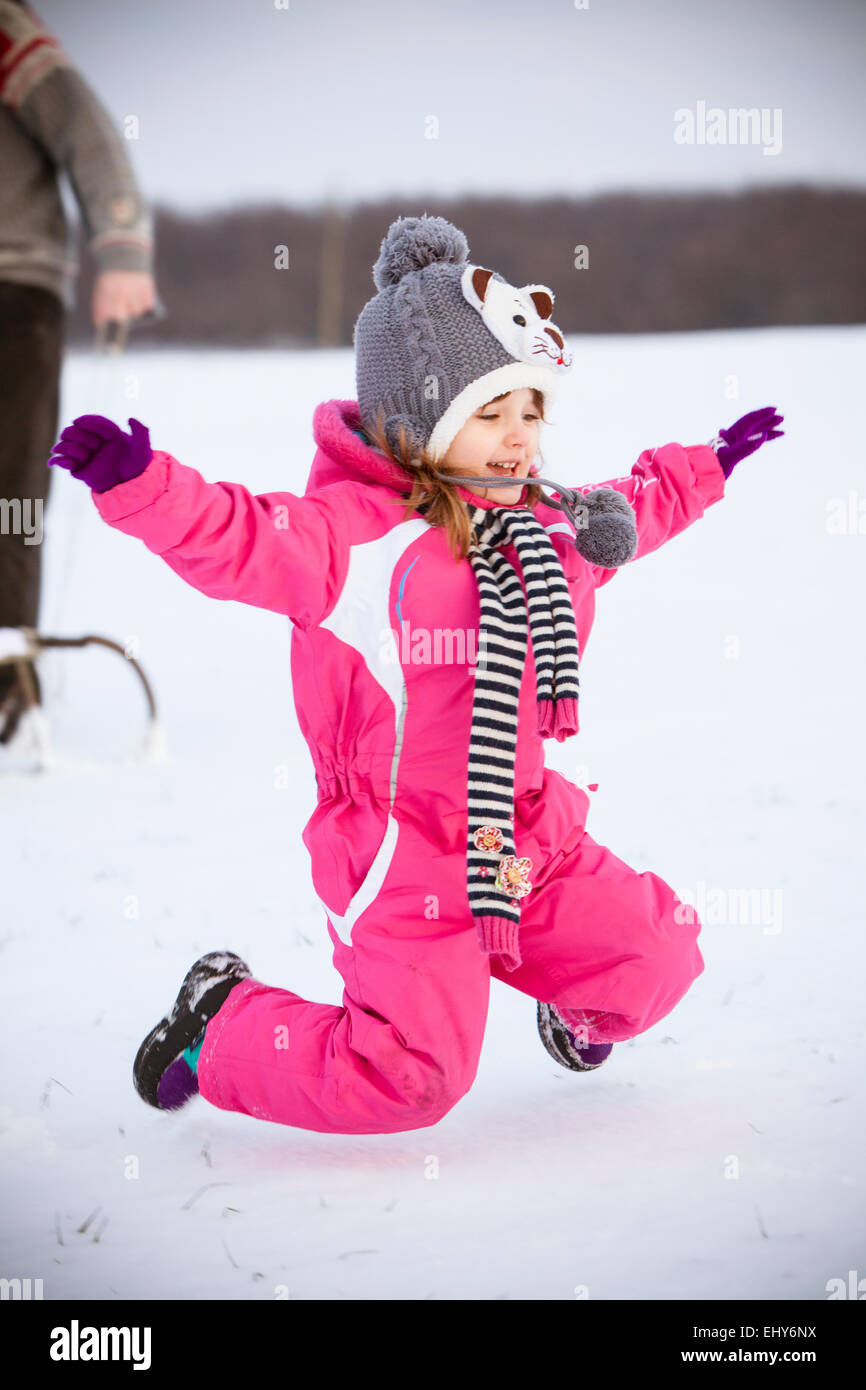 Girl jumping in snow Stock Photo