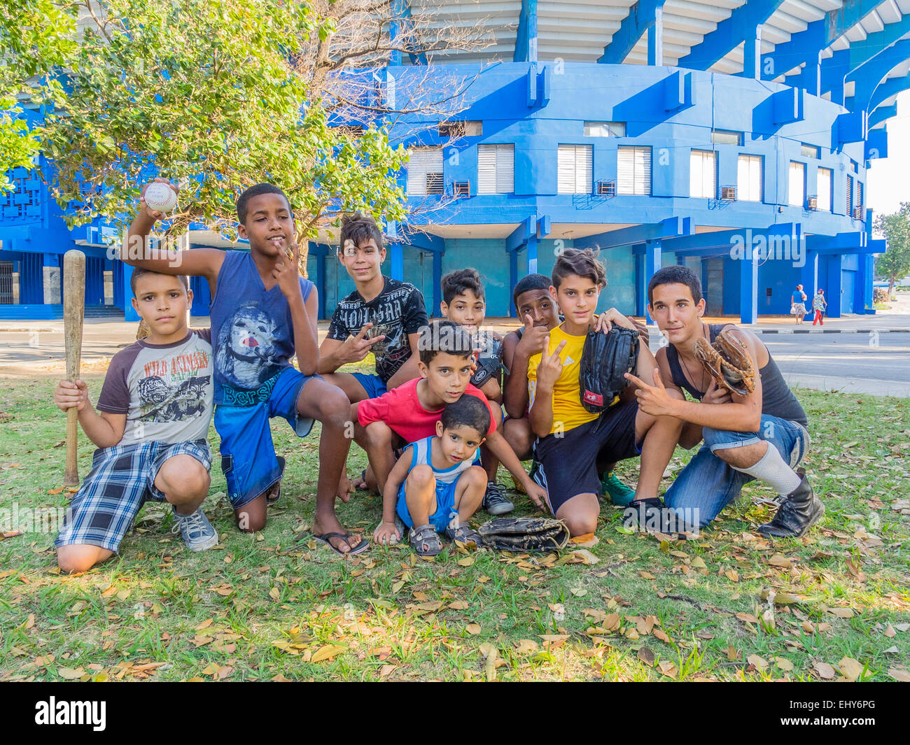 A group of young Cuban boys, who were playing a pick up game of baseball,  pose with their bat, ball and gloves in Havana. Stock Photo