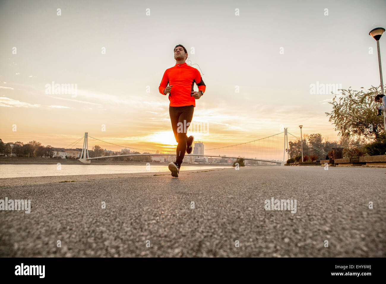 Man jogging on the waterfront against city skyline Stock Photo