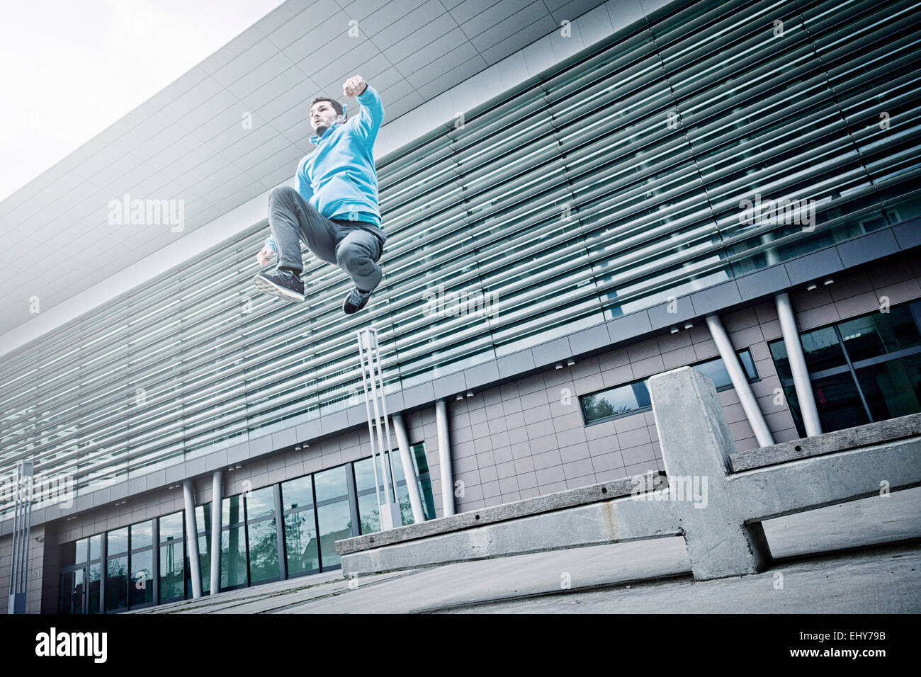 Male runner jumping in city Stock Photo