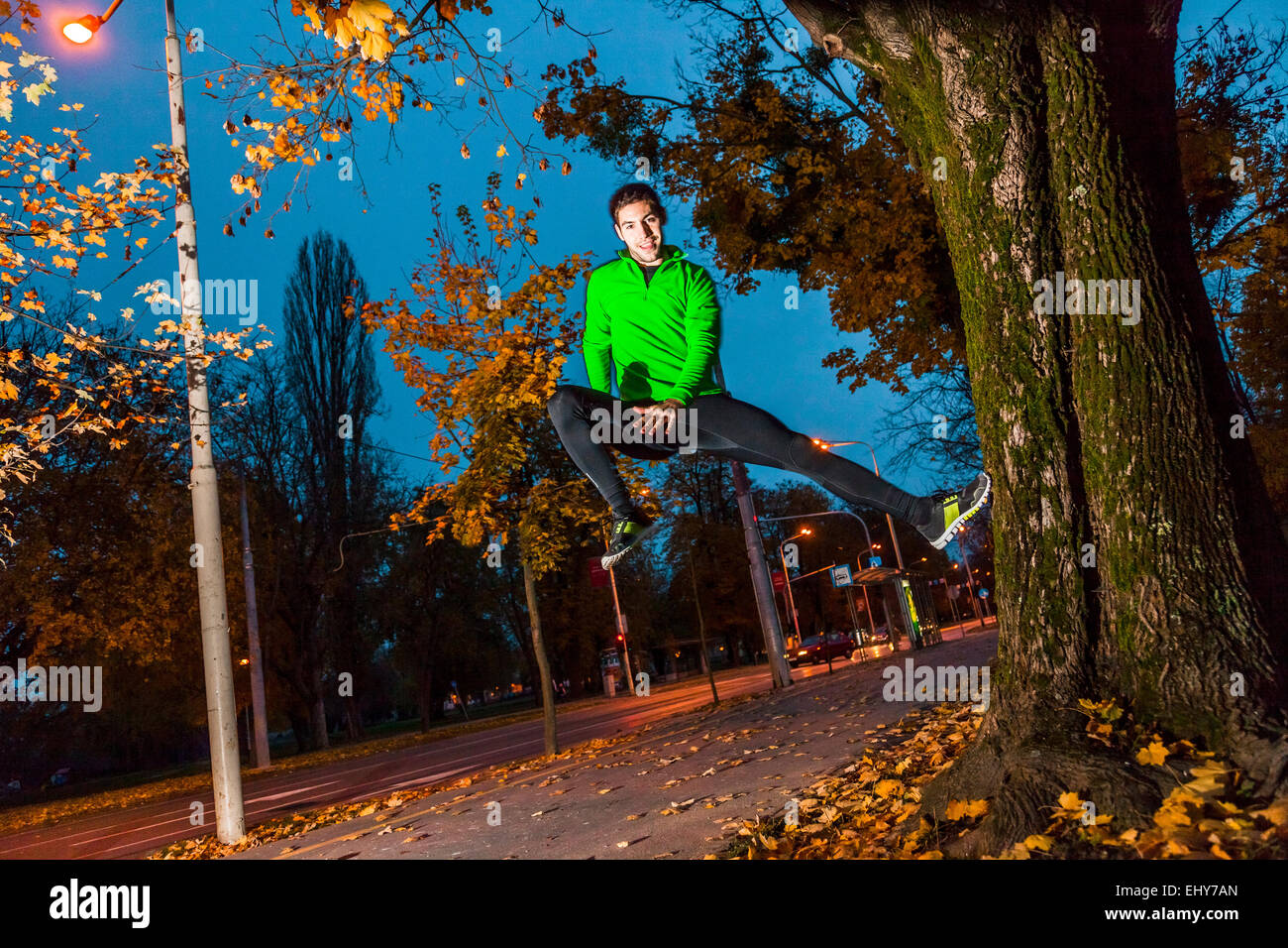 Male runner jumping in park Stock Photo