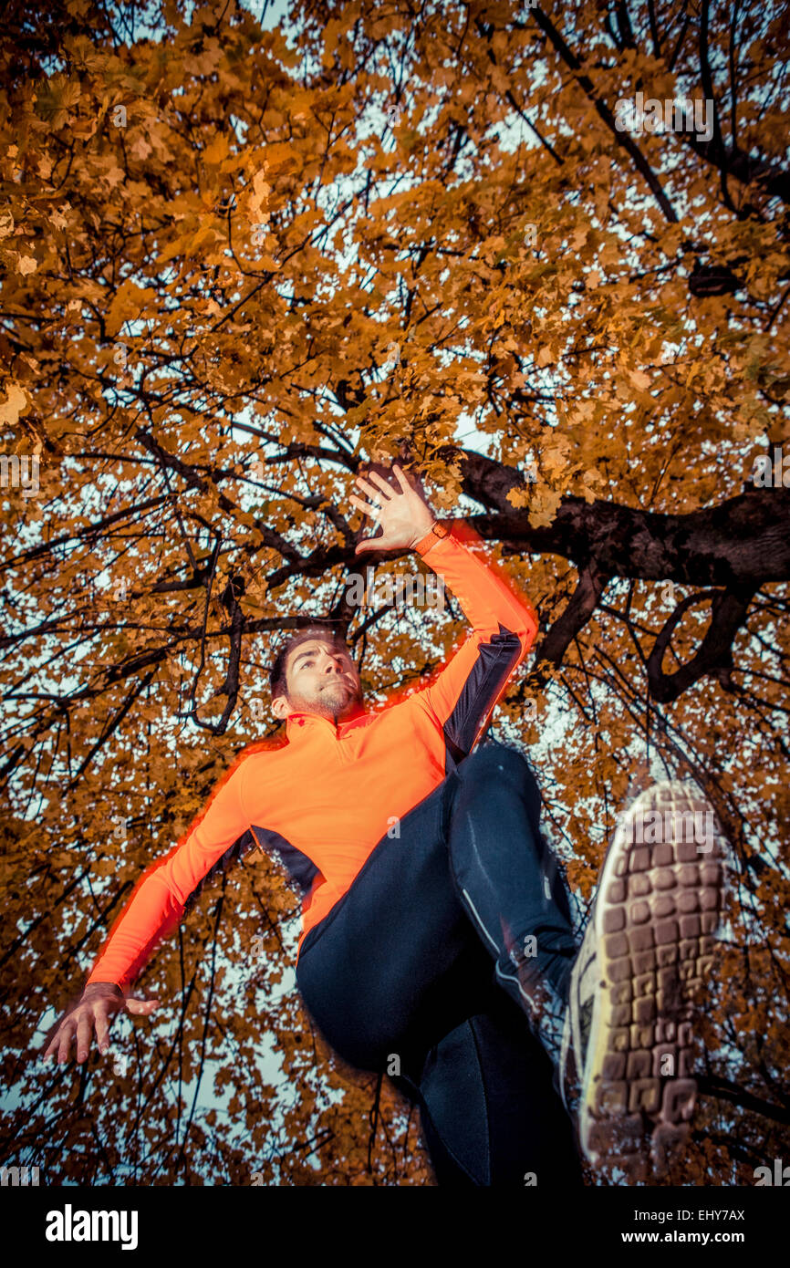 Male runner jumping and warming up in park Stock Photo