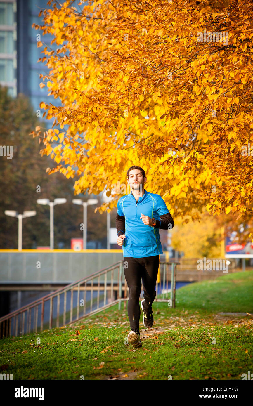 Male runner jogging in autumn park Stock Photo