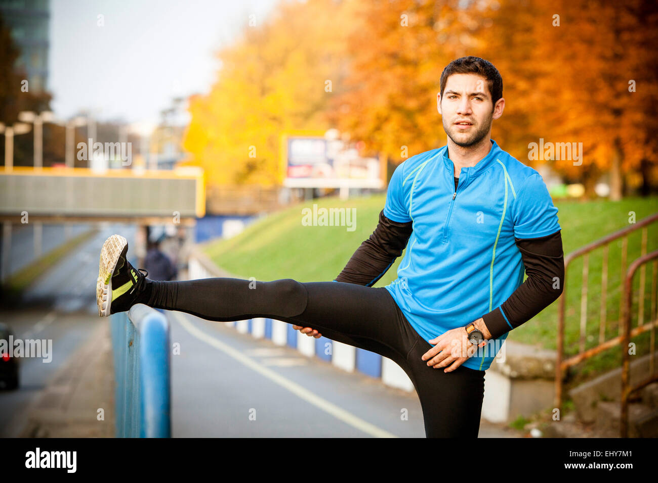 Male runner stretching and warming up in city Stock Photo