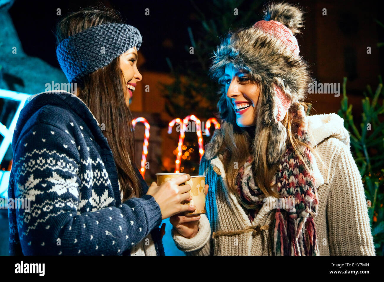 Two young women drinking punch at Christmas Market Stock Photo