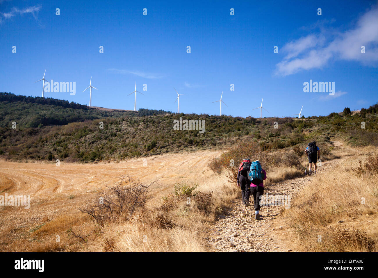 Pilgrims walking the Camino to Santiago de Compostela route near Zariquiegui Spain, a steep climb towards the Alto de Perdon. Stock Photo