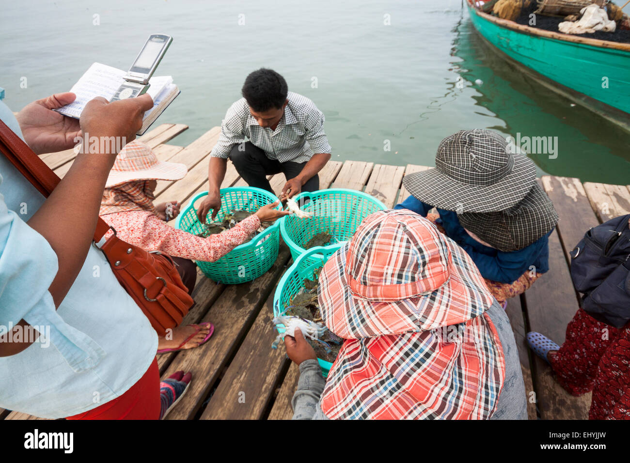 Crab Market in Kep, Cambodia. Traditional occupation for make a living. People sorting and calculating their share from income. Stock Photo
