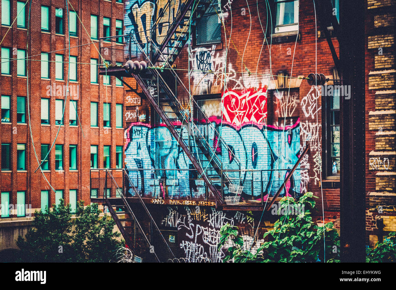 Graffiti and stairs on the side of a brick building seen from the Reading Viaduct, in Philadelphia, Pennsylvania. Stock Photo