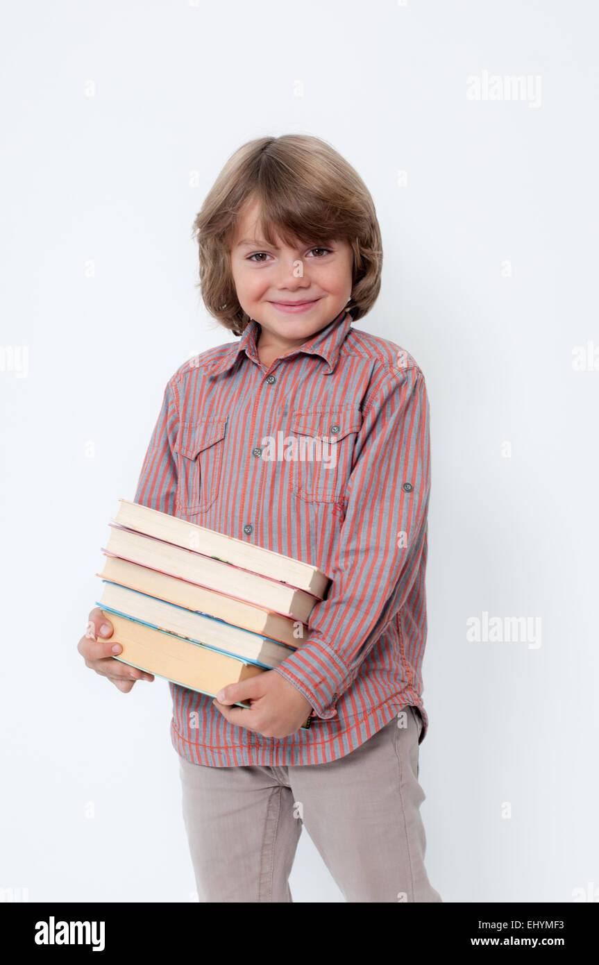 Boy holding a pile of books Stock Photo