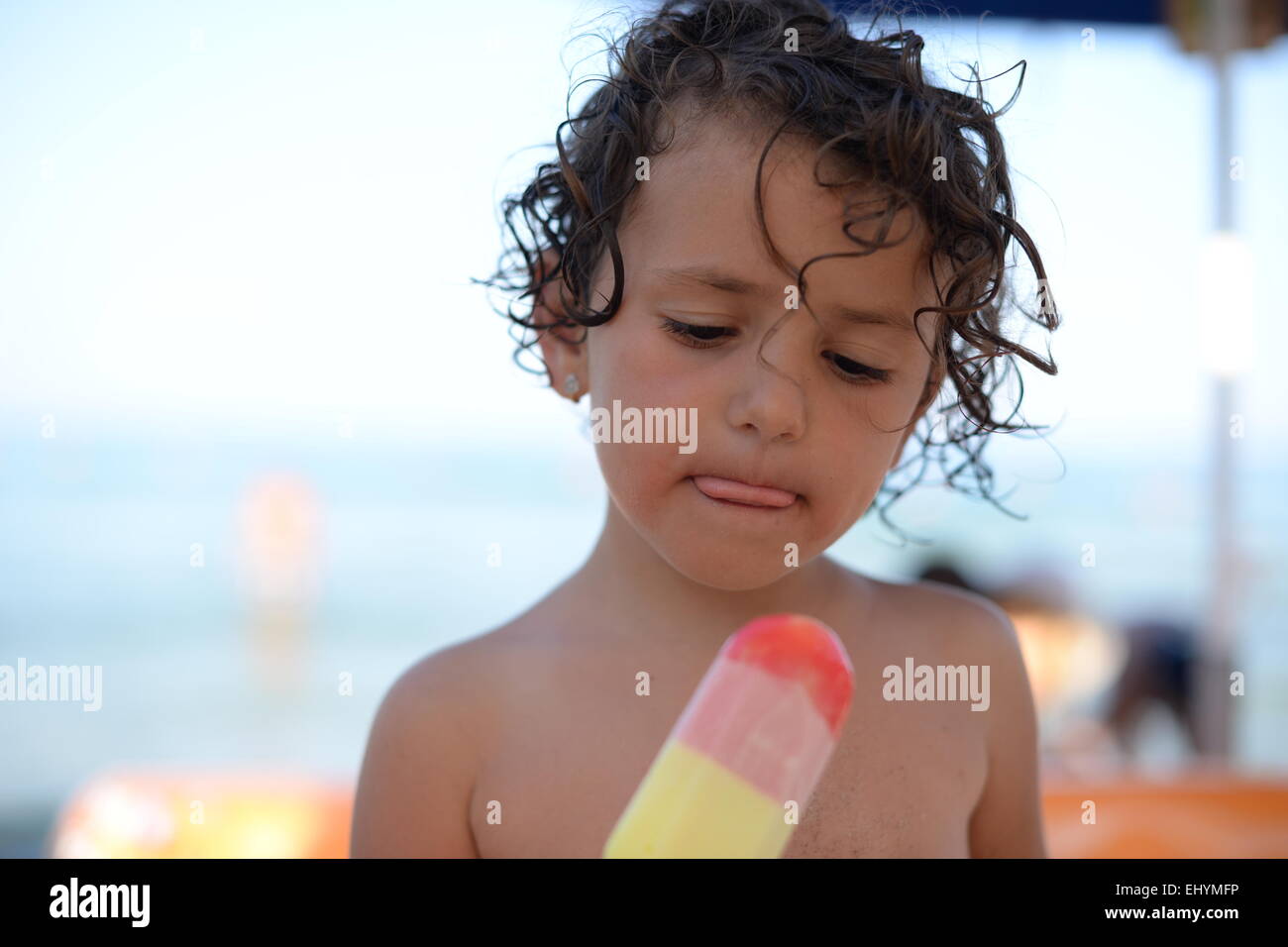 Girl eating an ice-cream on the beach, Thassos, Greece Stock Photo