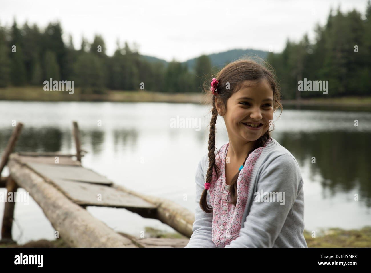 Smiling Girl sitting by a lake Stock Photo - Alamy