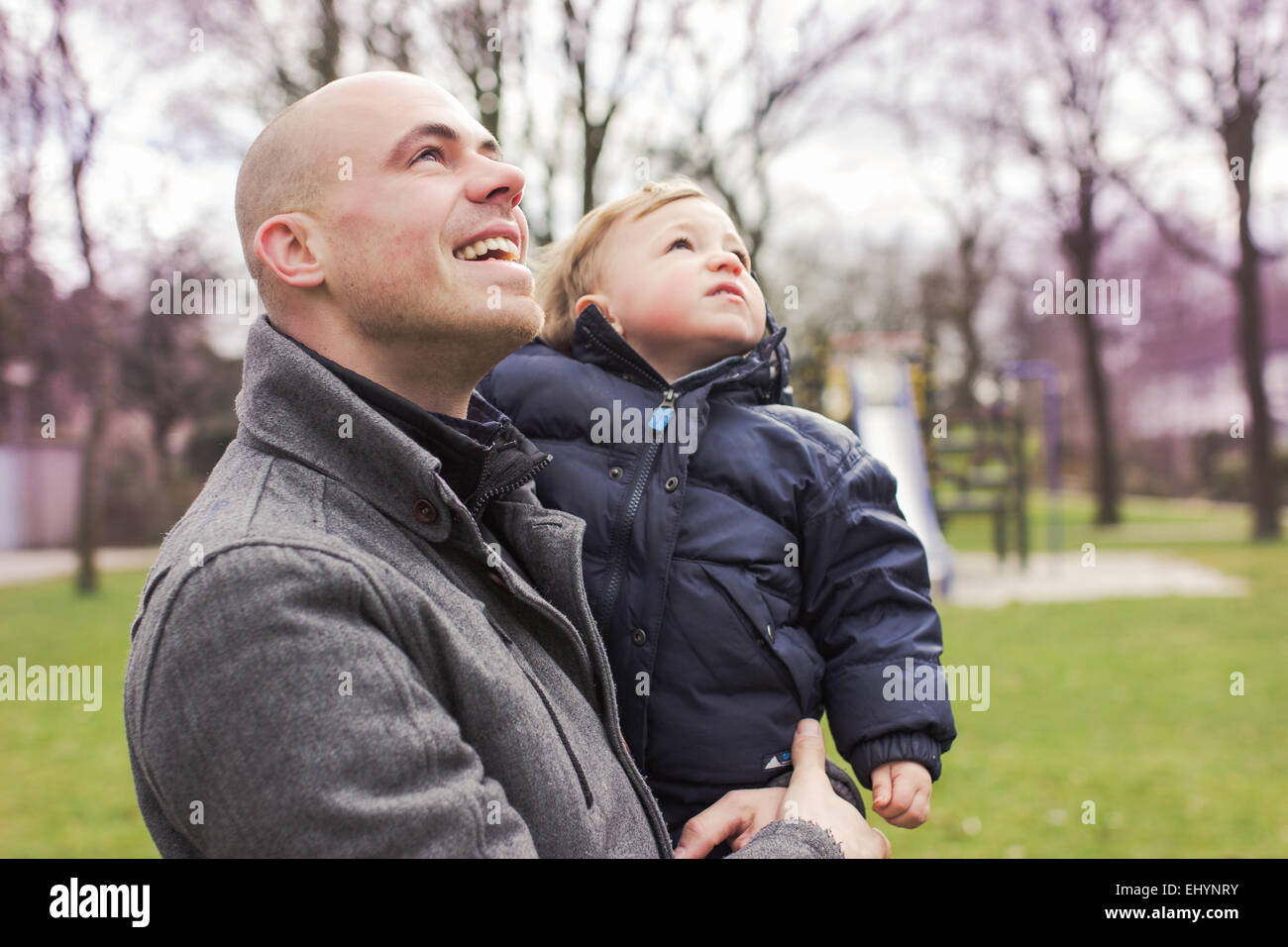 Father carrying baby son and looking up Stock Photo