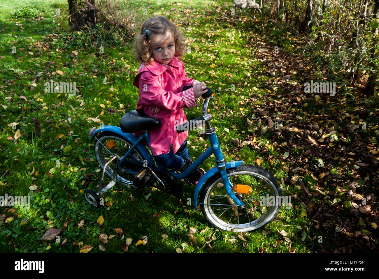 Girl standing in the park with her bicycle Stock Photo