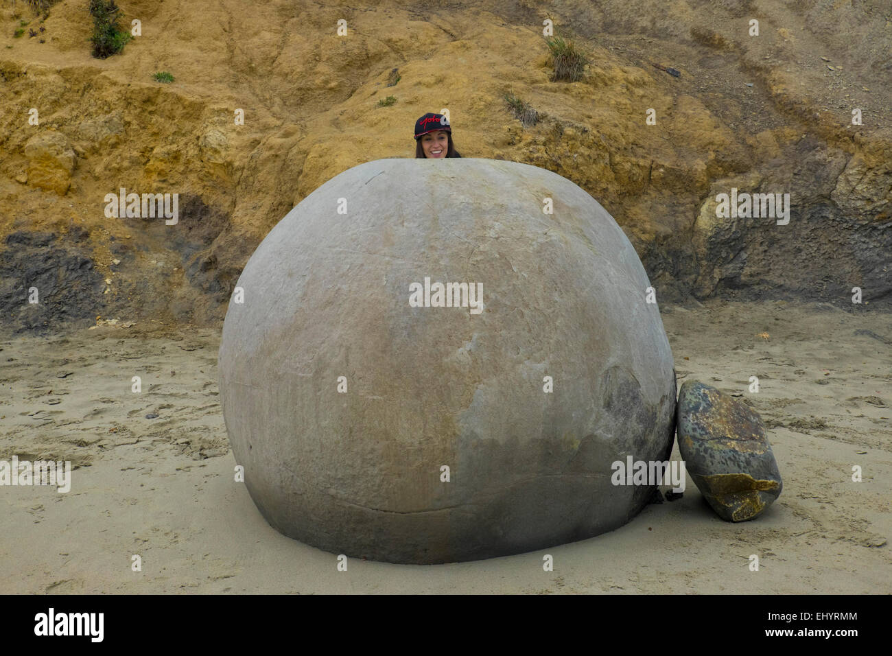 Girl behind unusual shaped boulders, Koekohe Beach, South Island, New Zealand Stock Photo