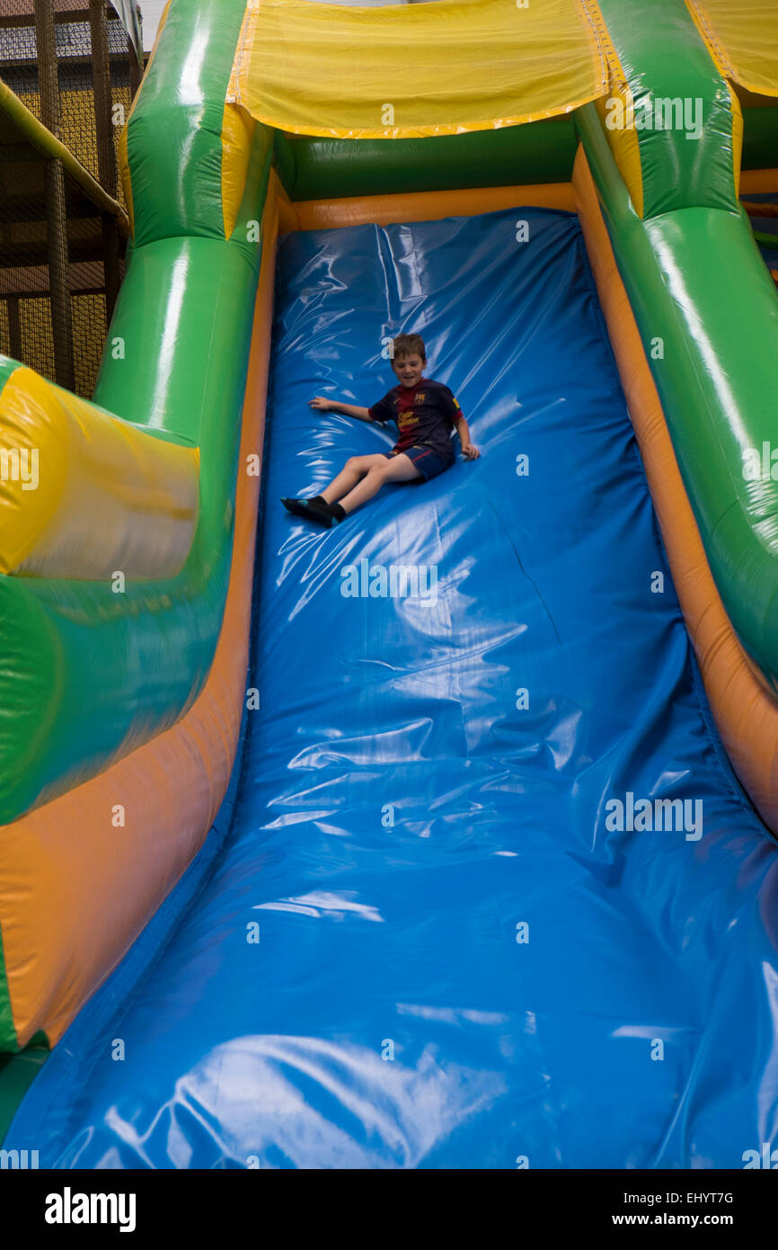 Boy on slide in soft play area Stock Photo Alamy