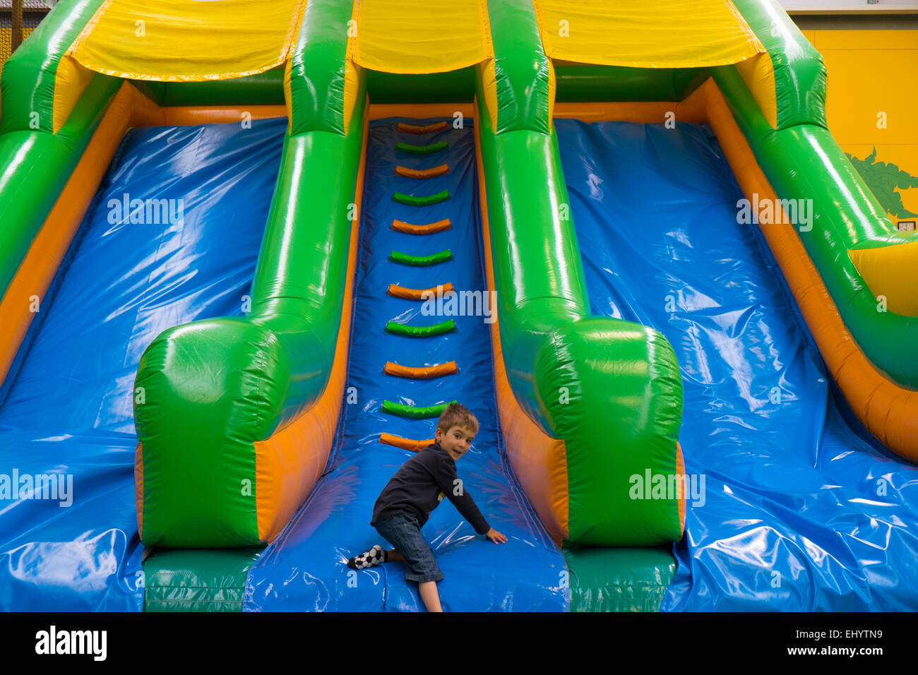 Boy on slide in soft play area Stock Photo
