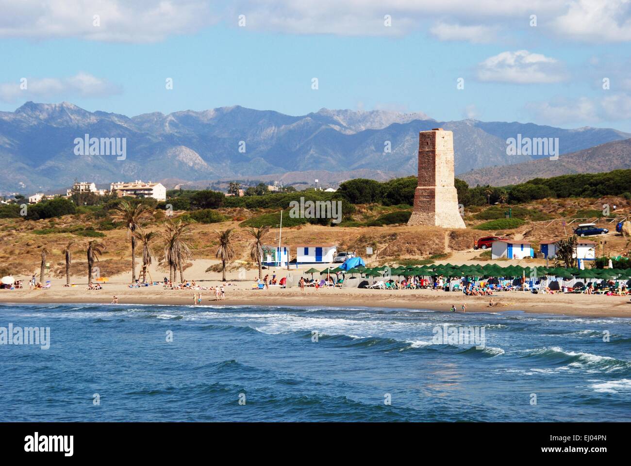 View of the beach with the watchtower and mountains to the rear, Puerto Cabopino, Costa del Sol, Malaga Province, Spain. Stock Photo
