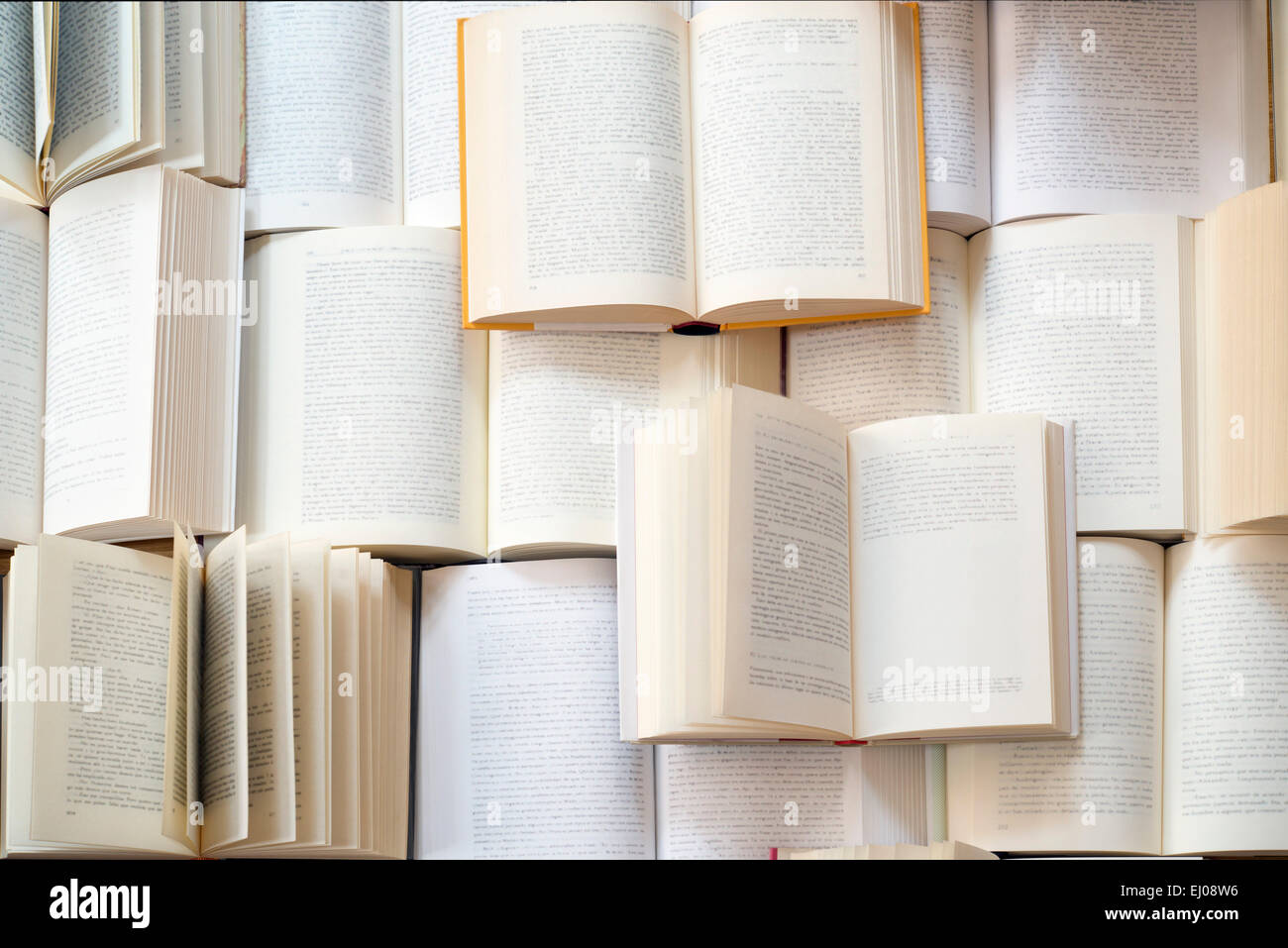 Many open books piled up. unreadable text Stock Photo