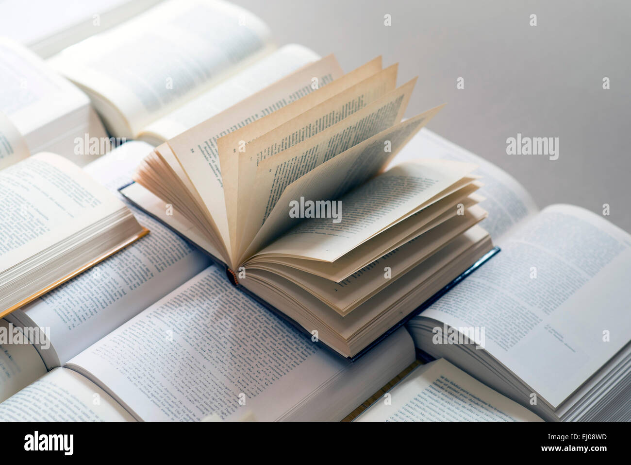 Many open books piled up. unreadable text. Copy space Stock Photo
