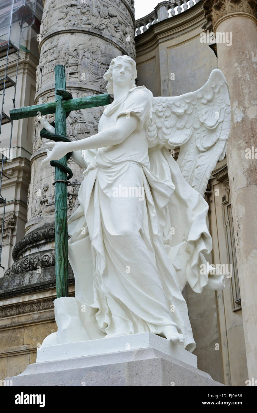 An angel statue holding a wooden cross outside the Karlskiche (St