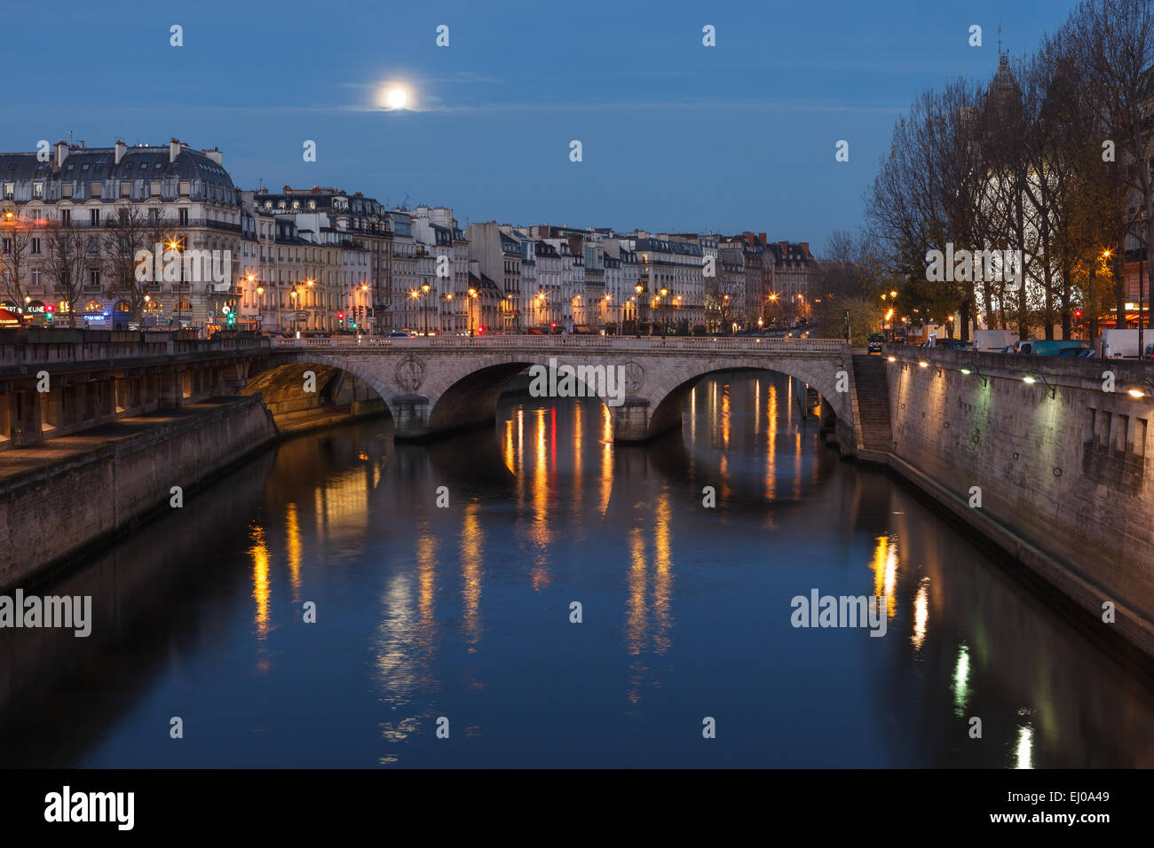 View of the Seine River and Paris by dawn, with the moon rising in the sky. Paris, Ile de France, France. Stock Photo