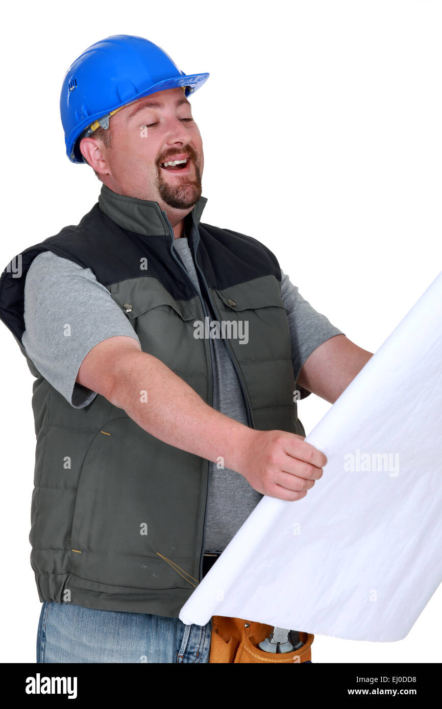 Builder laughing at plans Stock Photo