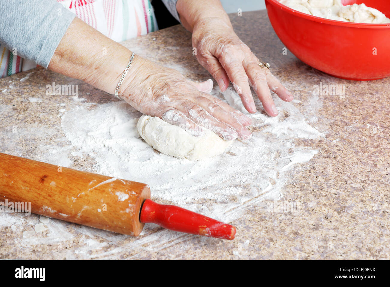 Senior woman hands making dough for a pie in her home kitchen Stock Photo