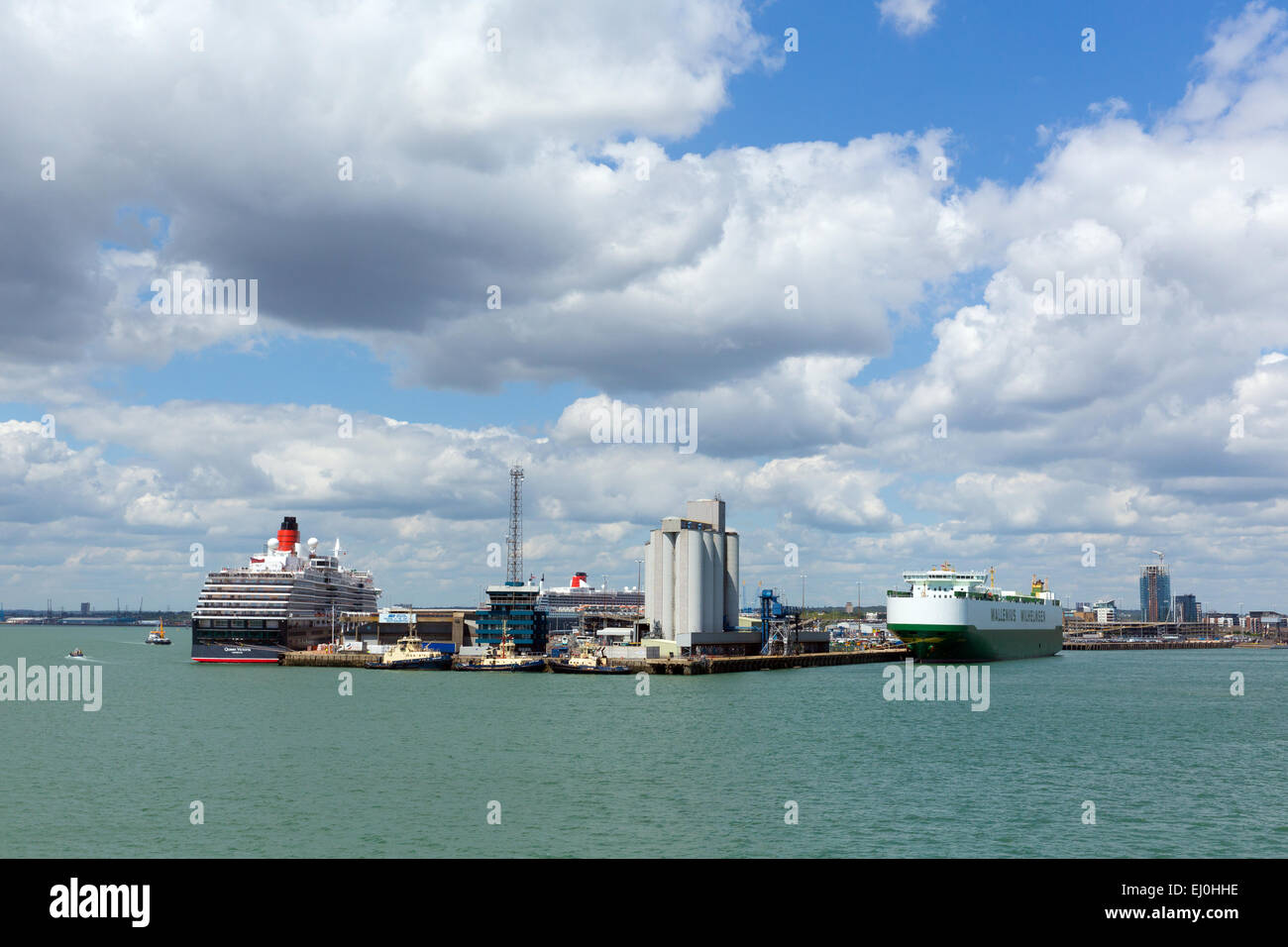 Southampton Docks With Big Cruise Ship And Cargo Vessel On Calm Summer Day With Fine Weather Blue Sky And White Clouds Southampton Docks With Big Cruise Ship And Cargo Vessel On Calm Summer Day With Fine Weather Blue Sky And White Clouds