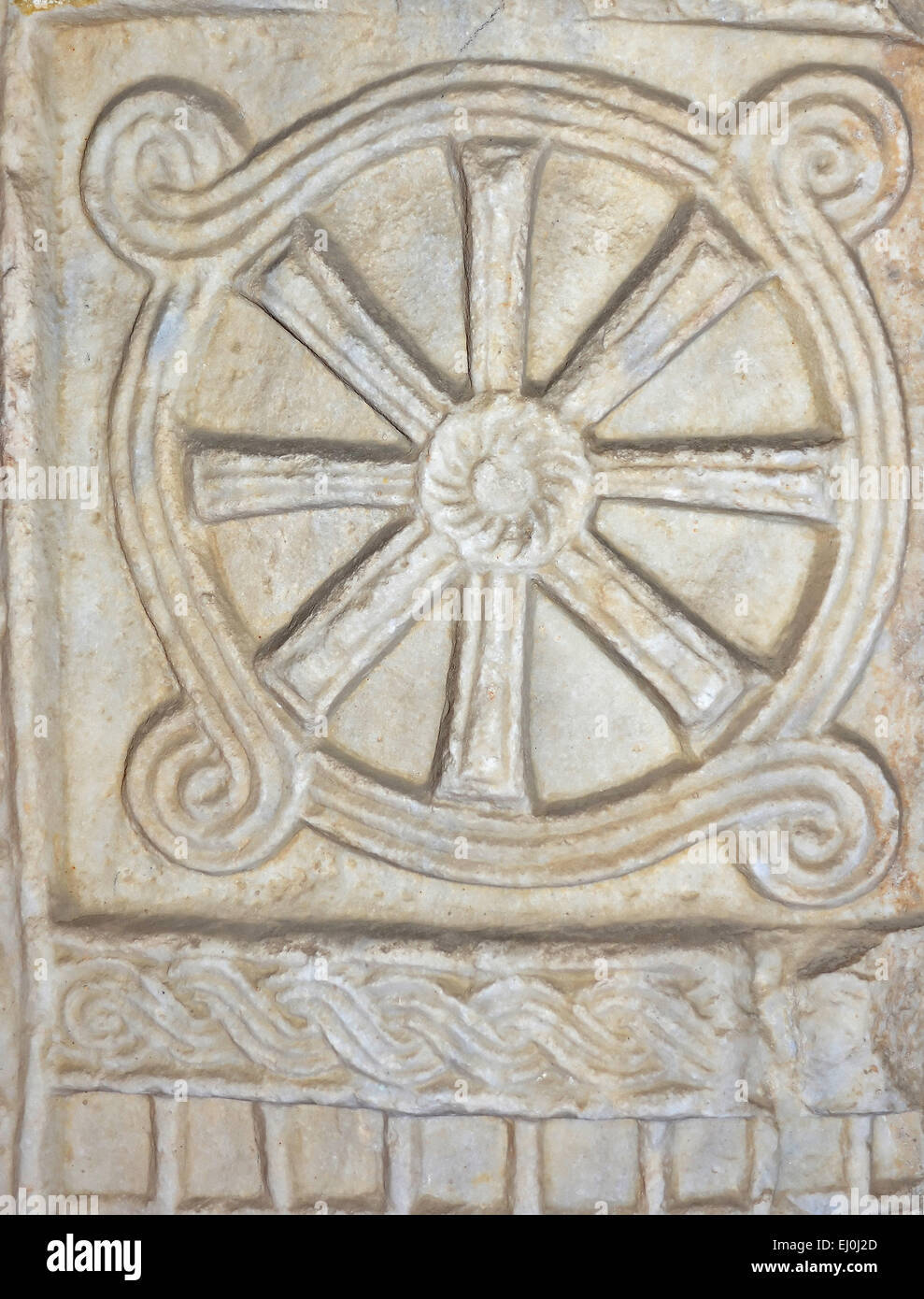 Ancient roman maritime design based on a ship's wheel and waves at sea, carved out of marble Stock Photo