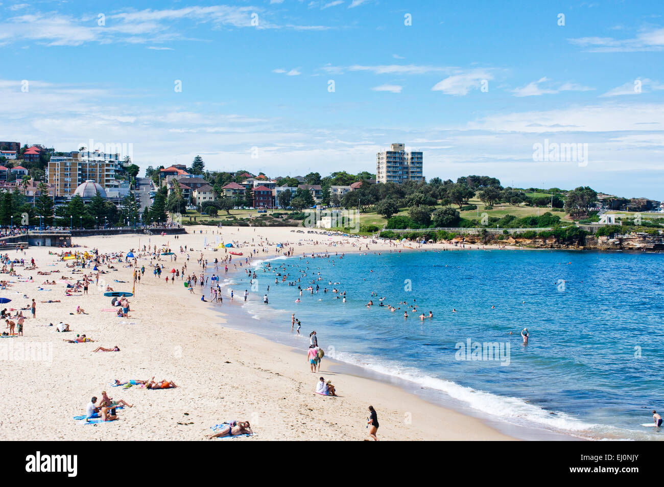 Packed with swimmers and sunbathers, the left side curve of Coogee Beach in Sydney, Australia on a bright and sunny day. Stock Photo