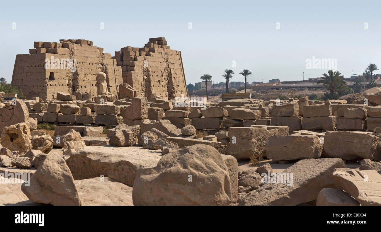 View over magazines of broken blocks to the colossal statues in front of the Eighth Pylon at the Temple  at Karnak, Luxor Egypt Stock Photo