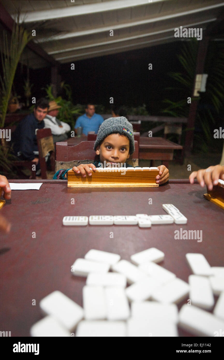 Caribbean, Republic of Cuba, Jan 2015 Vertical view of a young boy playing a game of dominoes being played in Cuba. Stock Photo
