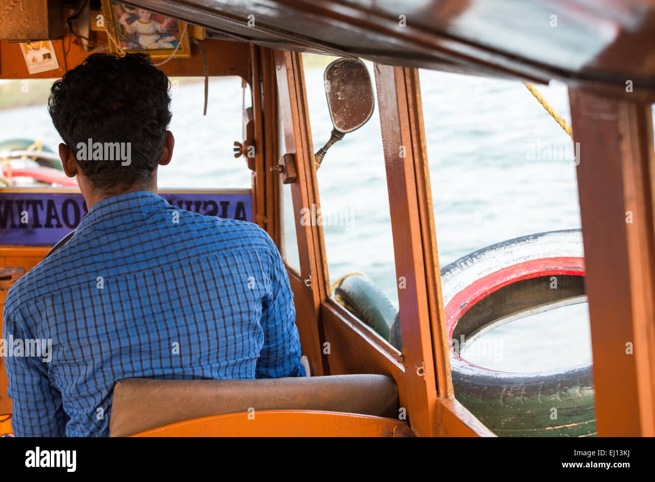 Driving a boat of tourists on the Vembanad Lake in Kumarakom, Kerala