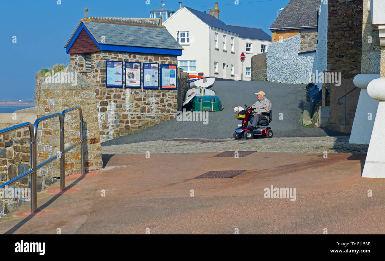Senior man on mobility scooter, on the quayside, Appledore, Devon