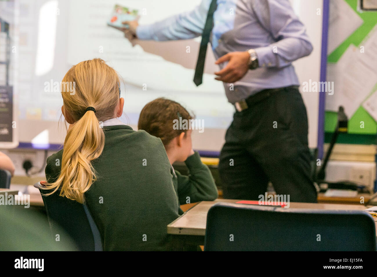 Primary school girls are taught during a lesson by a male teacher Stock Photo