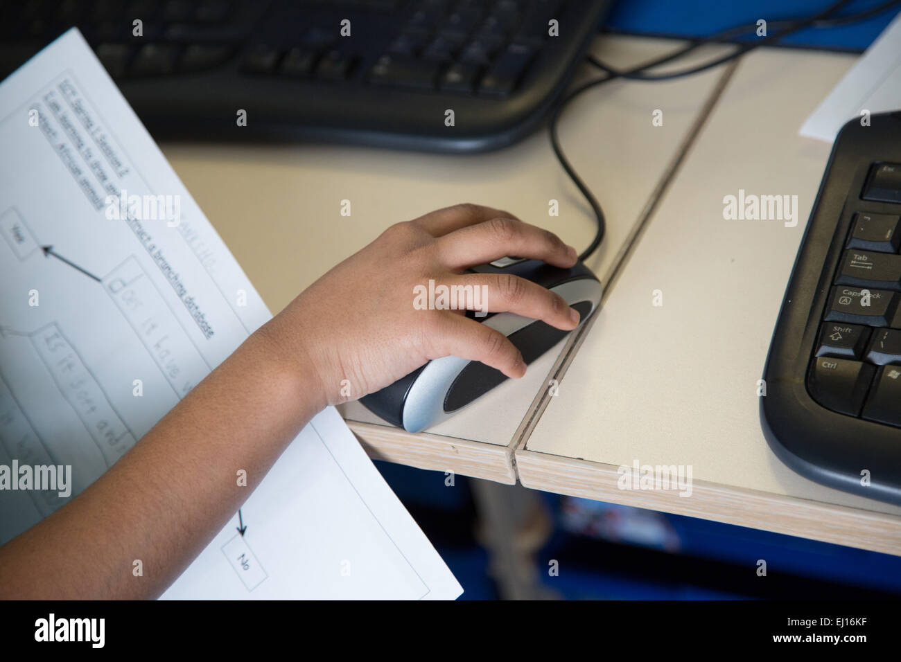 UK primary school child using a mouse and desktop PC computer in an ICT lesson Stock Photo