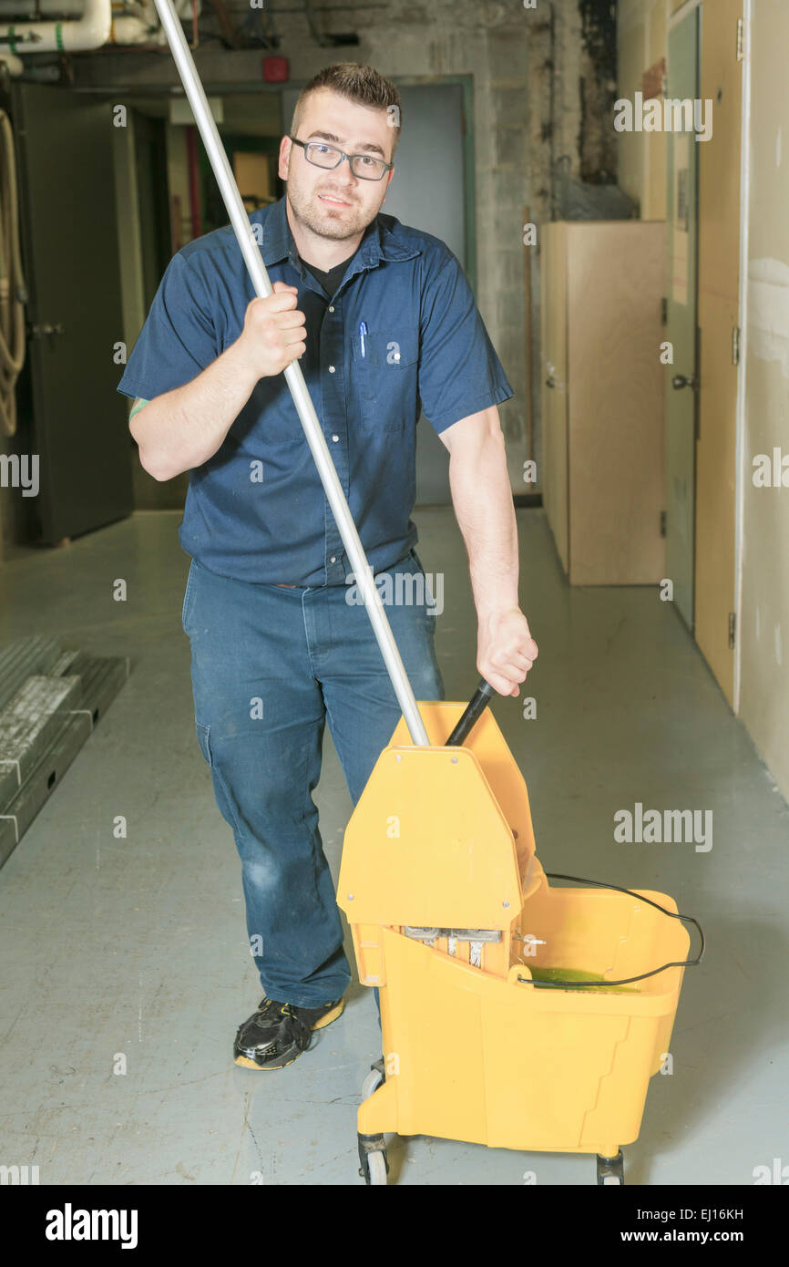 serviceman who cleaning the floor with his mop Stock Photo