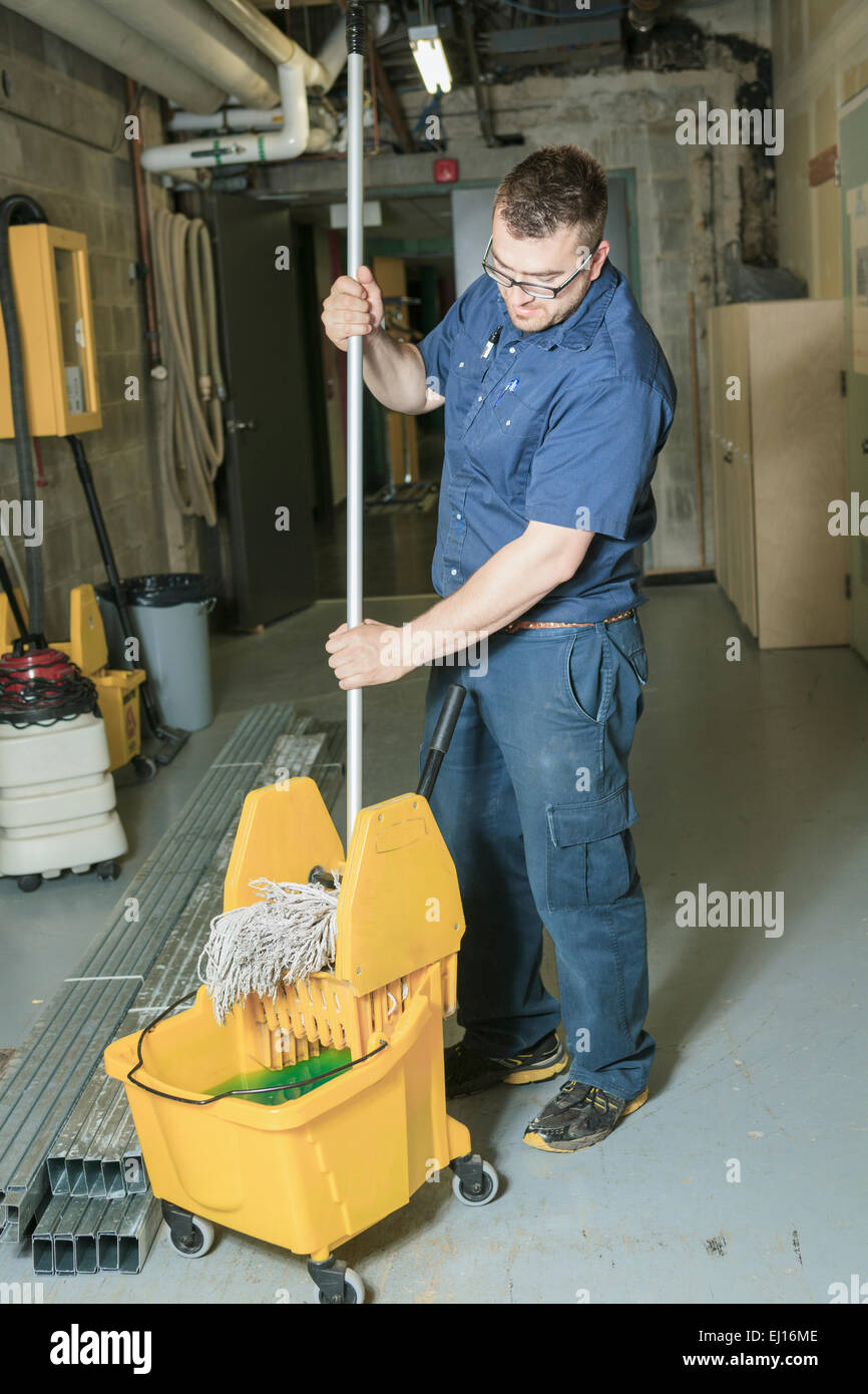 serviceman who cleaning the floor with his mop Stock Photo