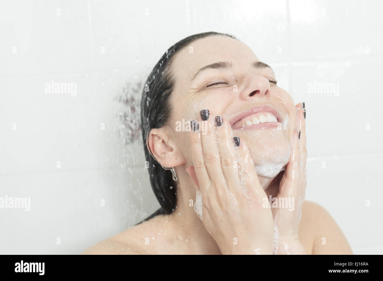 Shower woman. Happy smiling woman washing shoulder showering in Stock