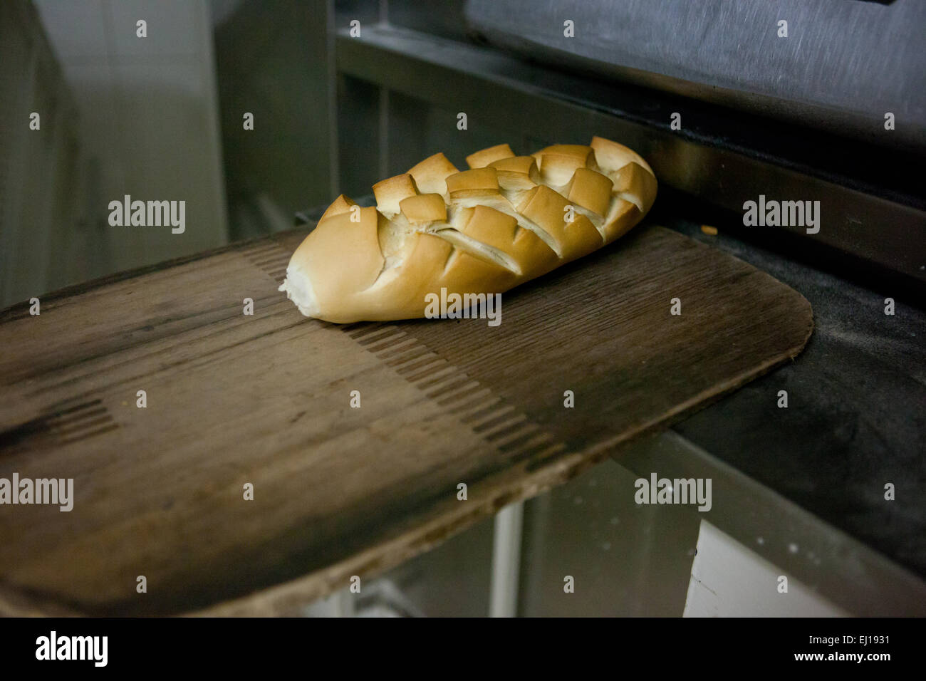 baking peel with a piece of fresh baked bread. Manufacturing process of