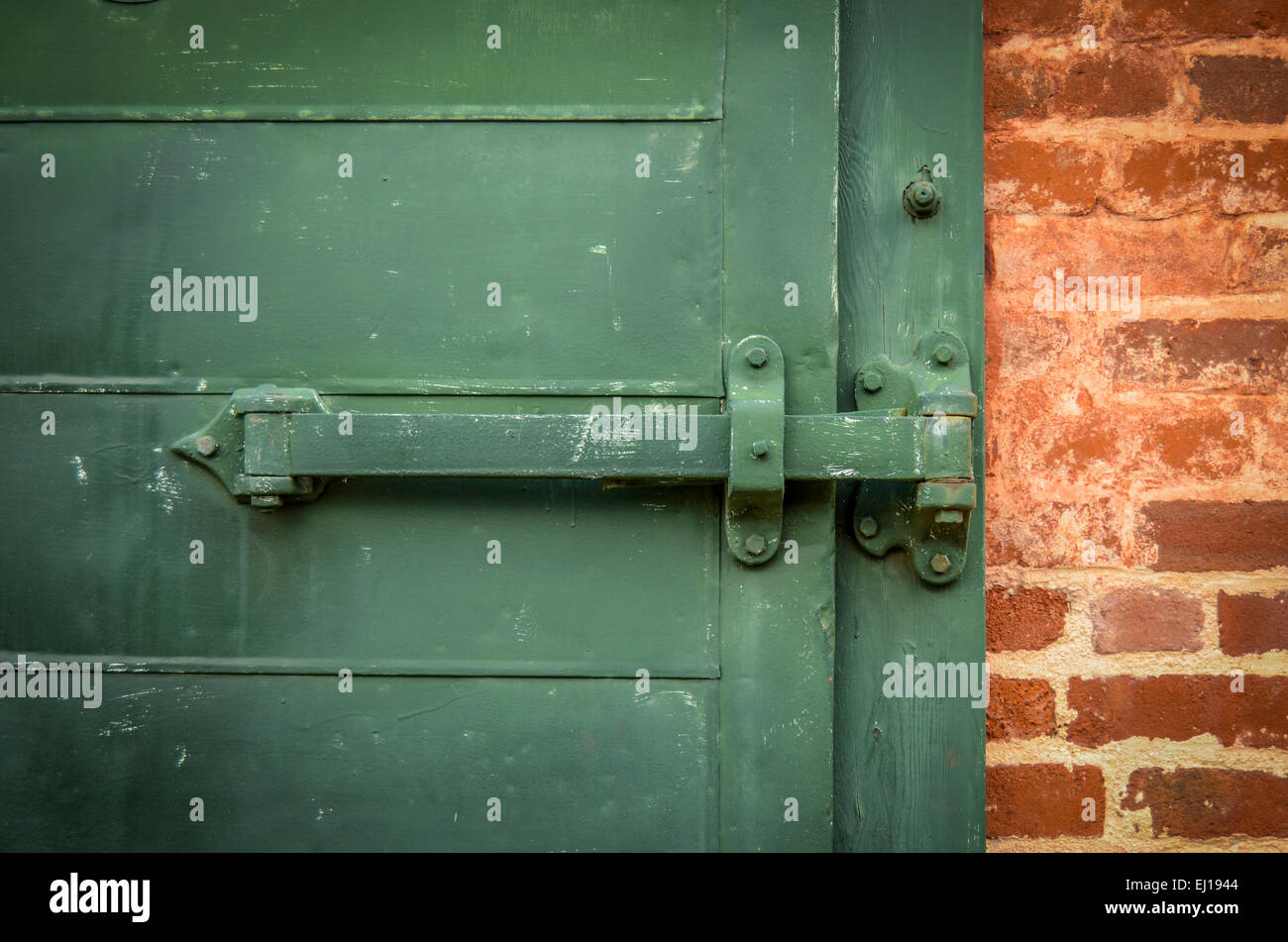 Detail Of Locked Heavy Industrial Green Door With Red Brickwork Stock Photo