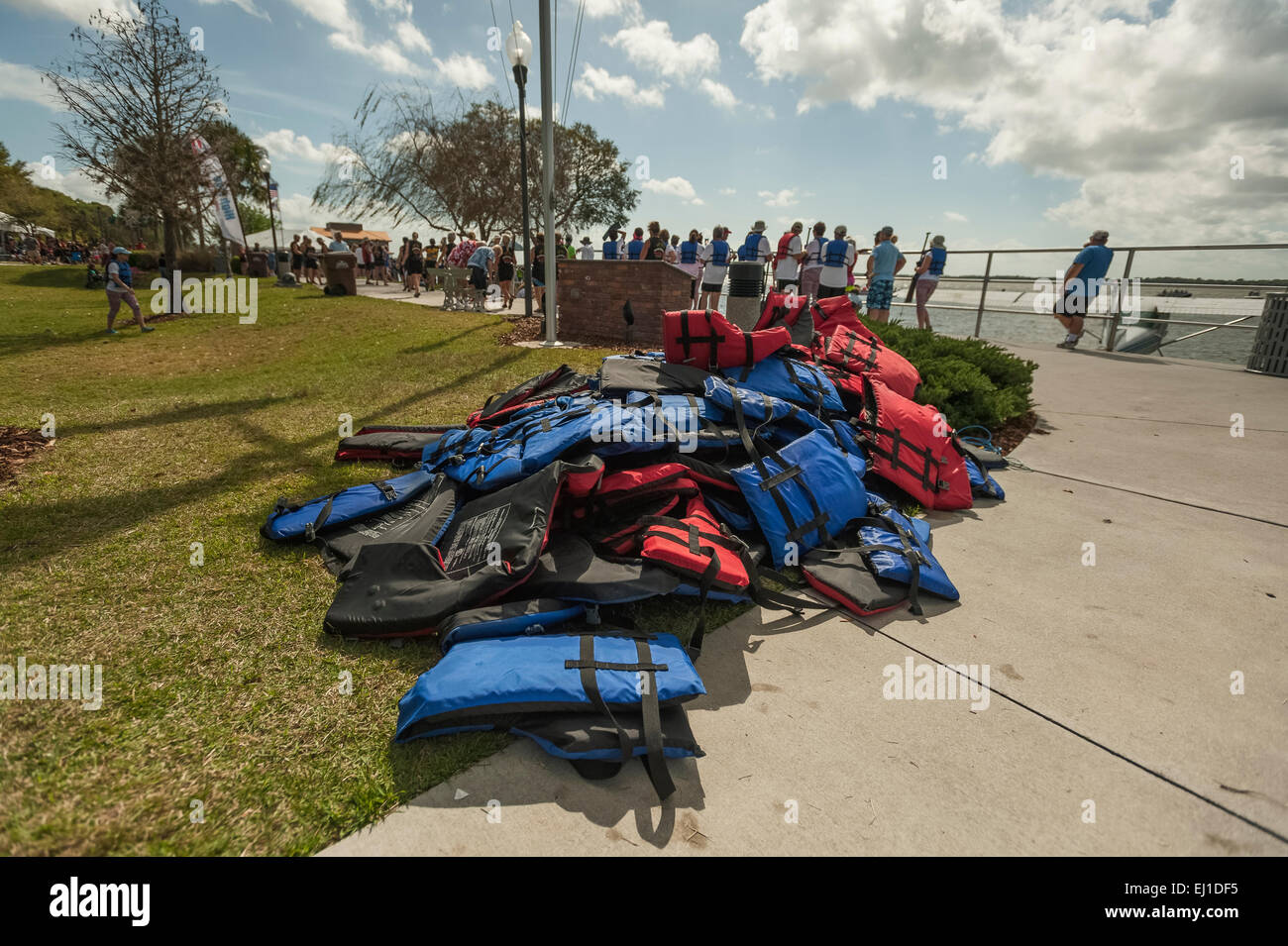 A collection of Coast Guard approved boating life vests stacked at waters edge awaiting a boating event at Wooton Park Tavares Stock Photo