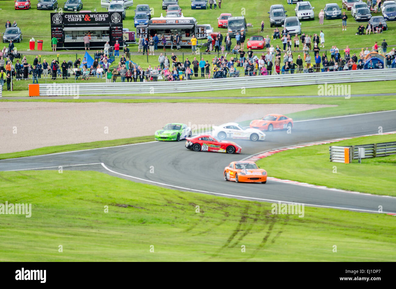 Crowd watches as drivers try to avoid two out of control cars after a collision at Oulton Park international curcuit Stock Photo